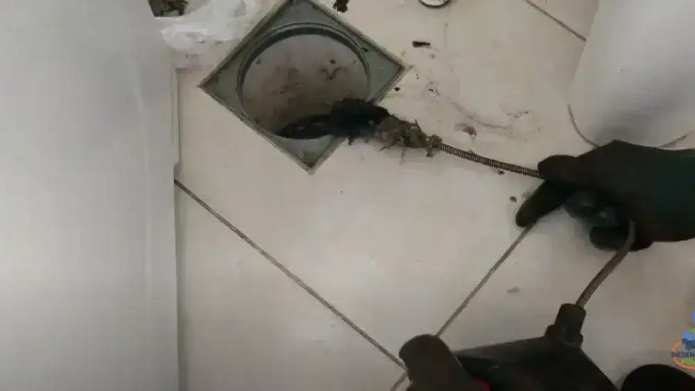 Profissional realizando desentupimento de ralo em residência em Curitiba